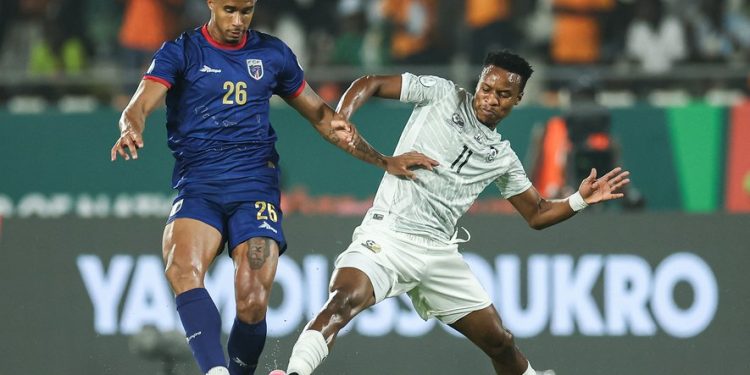 Cape Verde's midfielder #26 Kevin Pina (L) fights for the ball with South Africa's forward #11 Themba Zwane during the Africa Cup of Nations (CAN) 2024 quarter-final football match between Cape Verde and South Africa at the Stade Charles Konan Banny in Yamoussoukro on February 3, 2024. (Photo by FRANCK FIFE / AFP)