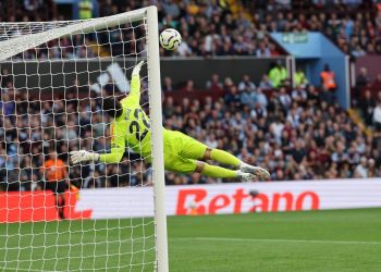 Arsenal's Spanish goalkeeper #22 David Raya dives as the ball comes back off the crossbar from a deflected shot from Aston Villa's Belgian defender #24 Amadou Onana during the English Premier League football match between Aston Villa and Arsenal at Villa Park in Birmingham, central England on August 24, 2024. (Photo by Adrian DENNIS / AFP) / RESTRICTED TO EDITORIAL USE. No use with unauthorized audio, video, data, fixture lists, club/league logos or 'live' services. Online in-match use limited to 120 images. An additional 40 images may be used in extra time. No video emulation. Social media in-match use limited to 120 images. An additional 40 images may be used in extra time. No use in betting publications, games or single club/league/player publications. /  (Photo by ADRIAN DENNIS/AFP via Getty Images)