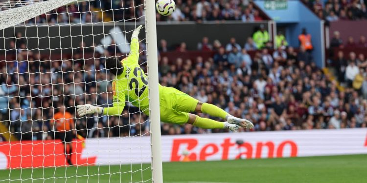 Arsenal's Spanish goalkeeper #22 David Raya dives as the ball comes back off the crossbar from a deflected shot from Aston Villa's Belgian defender #24 Amadou Onana during the English Premier League football match between Aston Villa and Arsenal at Villa Park in Birmingham, central England on August 24, 2024. (Photo by Adrian DENNIS / AFP) / RESTRICTED TO EDITORIAL USE. No use with unauthorized audio, video, data, fixture lists, club/league logos or 'live' services. Online in-match use limited to 120 images. An additional 40 images may be used in extra time. No video emulation. Social media in-match use limited to 120 images. An additional 40 images may be used in extra time. No use in betting publications, games or single club/league/player publications. /  (Photo by ADRIAN DENNIS/AFP via Getty Images)
